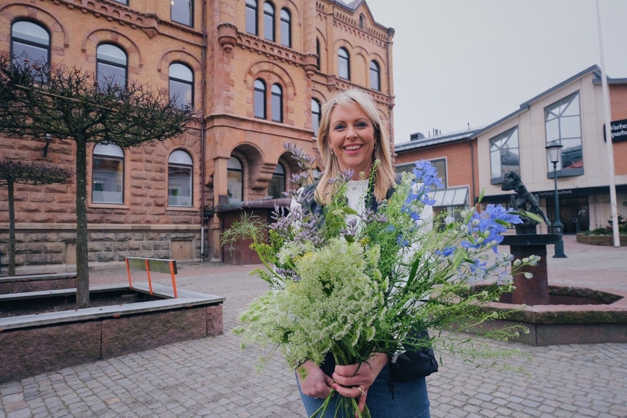 vår lantbruksrådgivare Maria Jahn håller en bukett med ängsblommor i famnen