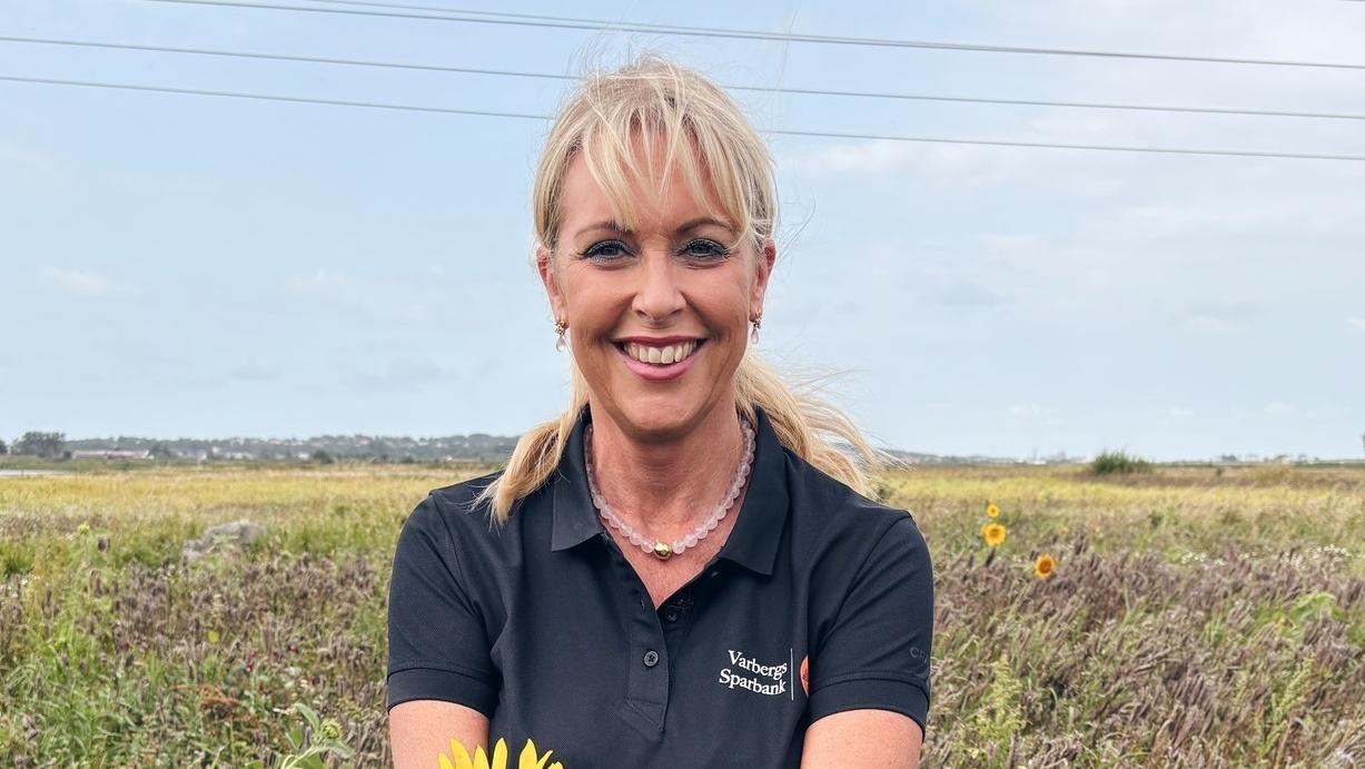 Maria Jahn sitter i ett blommande fält från projektet Hela Sverige blommar Halland