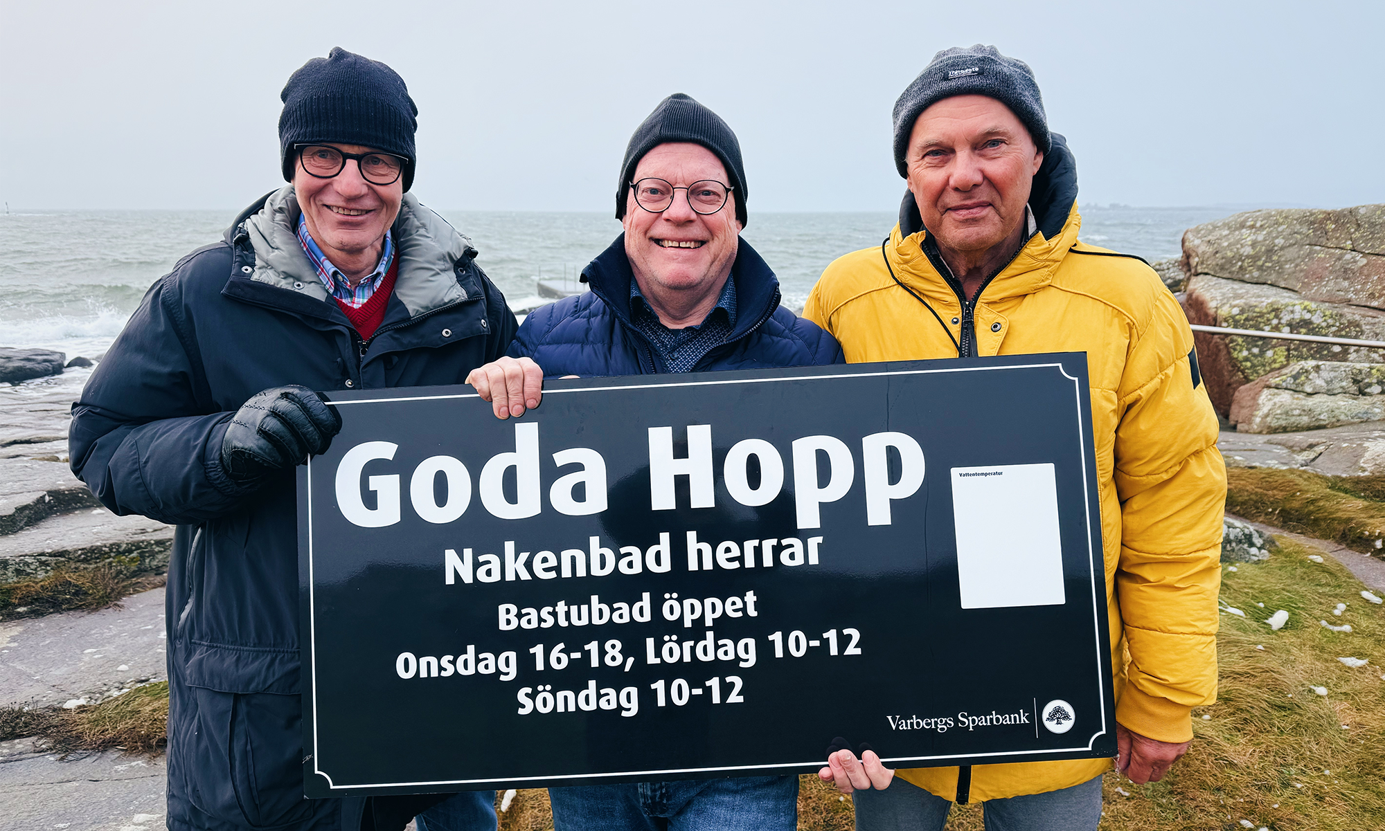 Tre män med en skylt