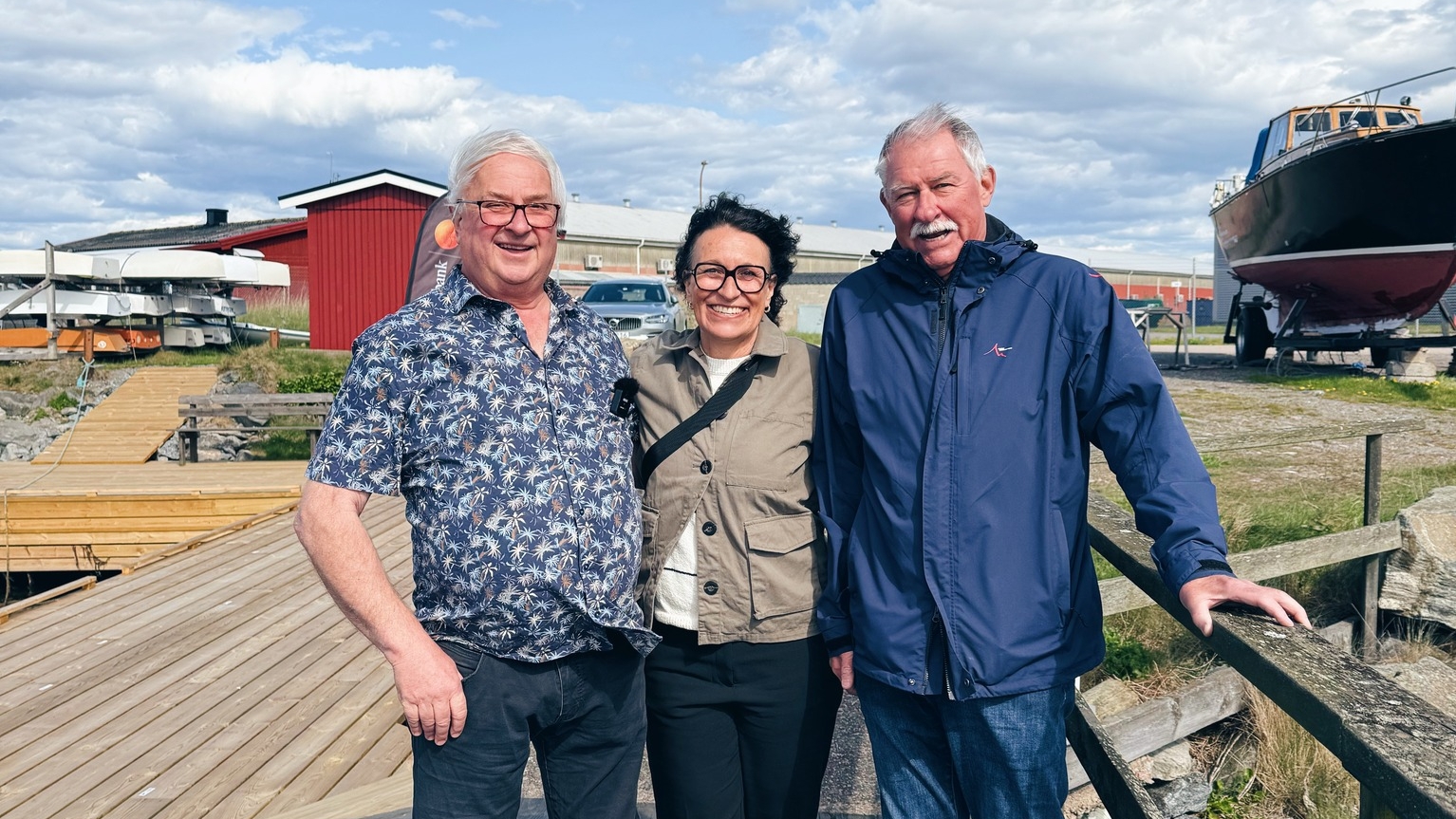 Tre glada människor som står på en brygga