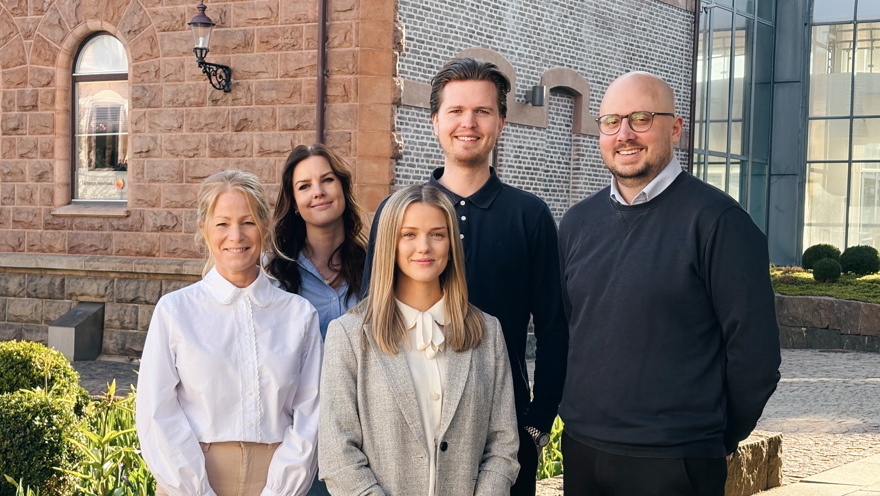 Ett foto på fem medarbetare på Varbergs Sparbank utanför banken