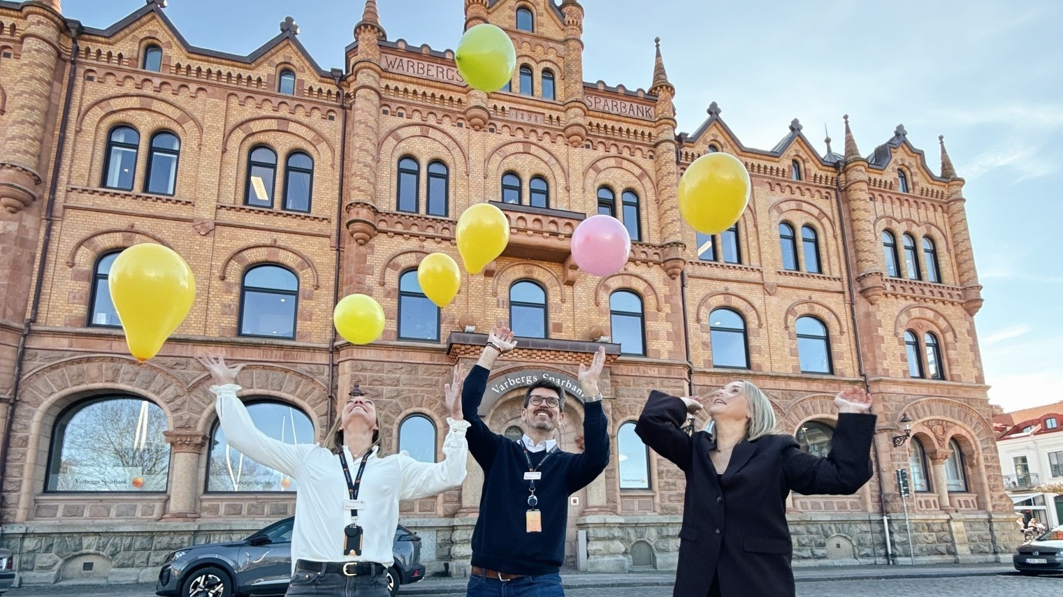 Ett foto på fyra personer med en tårta och ballonger